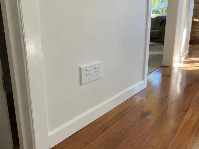 White double power point on a painted hallway wall above skirting, beside timber flooring in Arundel